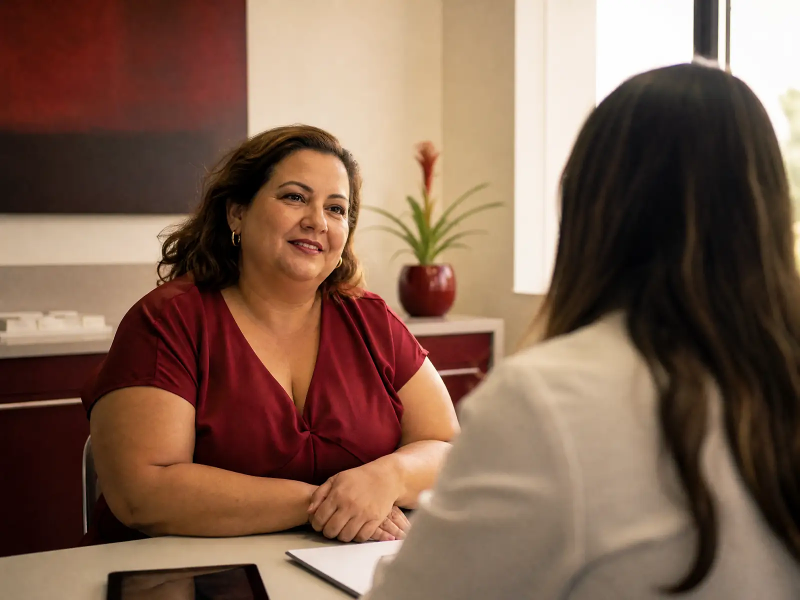 Mulher conversando com uma médica em um consultório